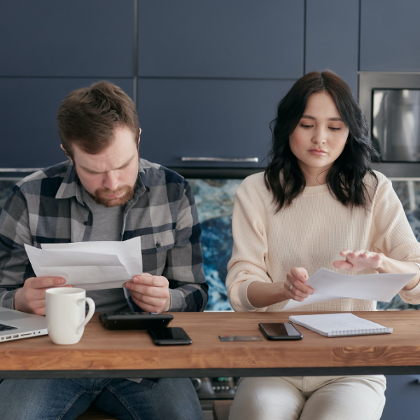 Man and woman looking at their debts, preparing to negotiate with creditors.